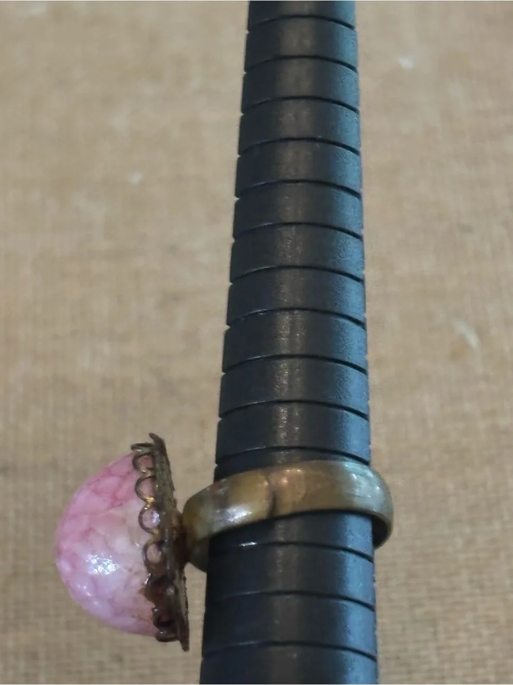 Pink cabochon stone set in an ornate, antiqued brass filigree setting Adjustable
